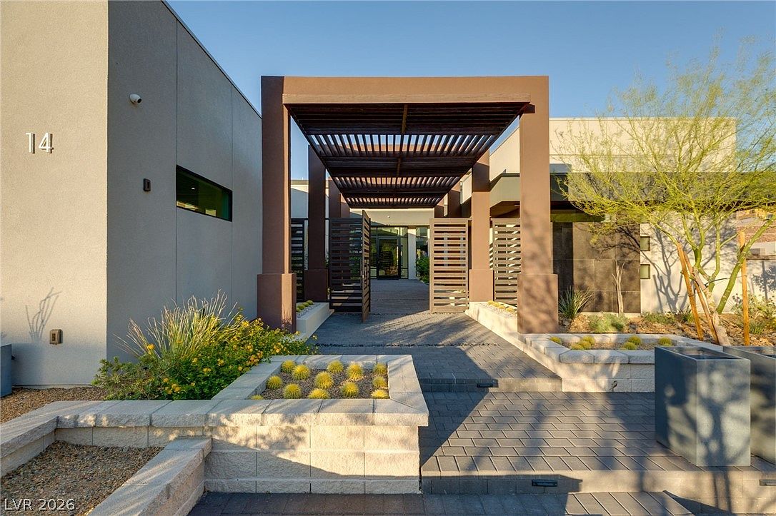Front entry courtyard with horizontal shade pergola, the address number 14, and desert plantings flanking the path