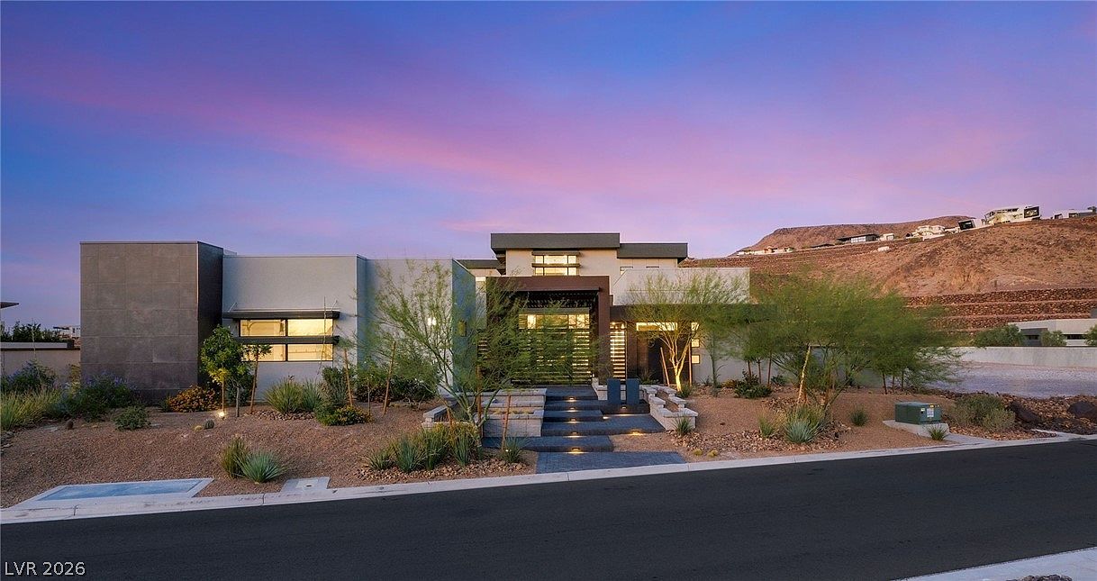 The residence at twilight with a lavender and pink Mojave sky over the modern horizontal massing