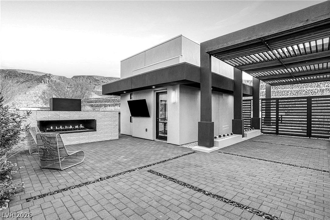 The same west patio scene rendered in black and white, the fire feature, woven chair, and ridge line drawn in tonal contrast